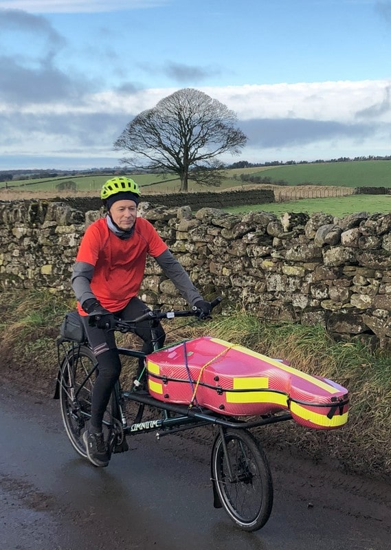 Pilgrim Cello 2 600x800-min Kenneth on his custom bike with the cello on the front riding along a country road in winter